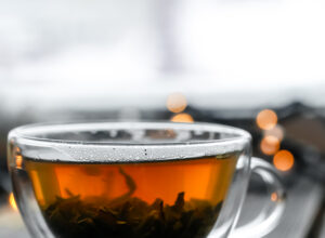 A clear glass cup of tea on a wooden table